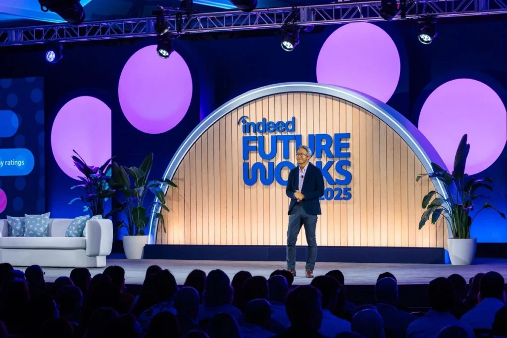 A speaker sharing insights on stage at the Indeed FutureWorks conference.