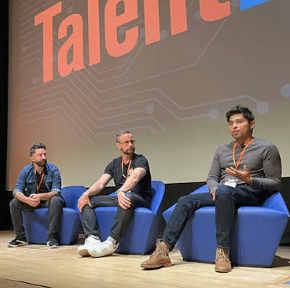 Speakers on stage at the Talent42 Tech Recruiting Conference, engaging in a panel discussion.