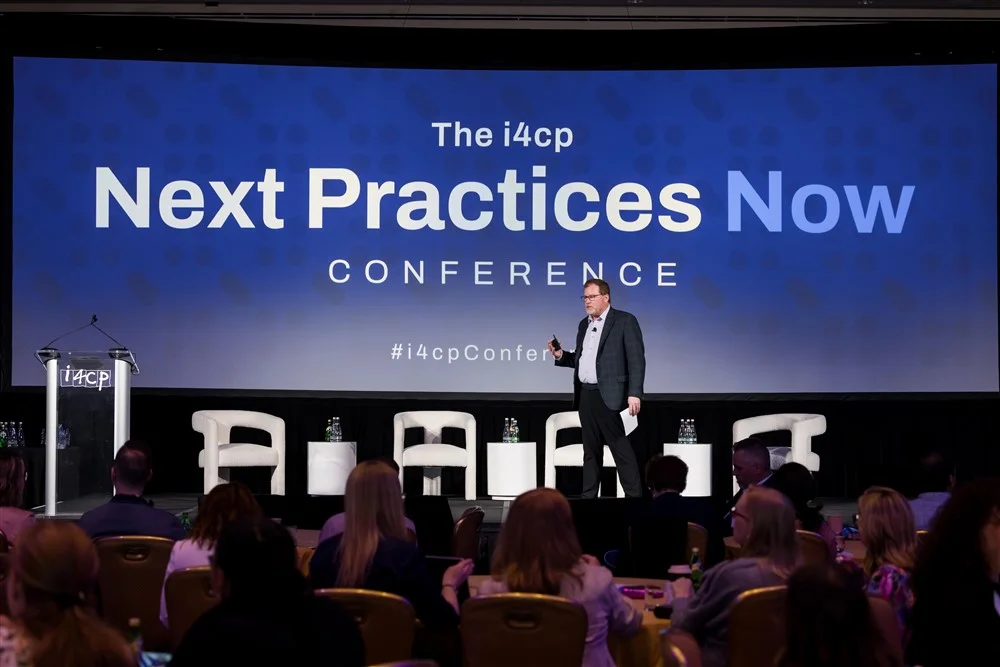 A speaker on stage at the Next Practices Now conference