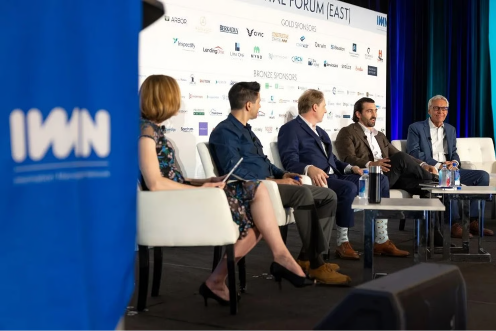 Five panelists seated on stage at IMN Real Estate CFO & COO Forum East conference.